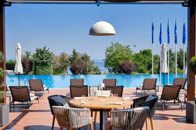 a patio with a table and chairs and a pool at Sozopol Santa Marina Sea View Studio in Sozopol