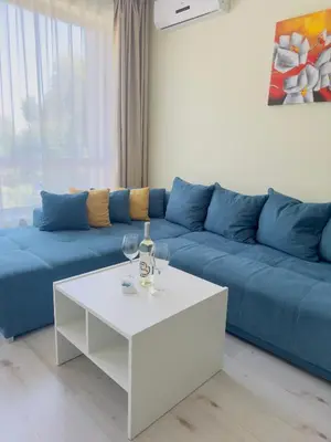 a living room with a blue couch and a white coffee table at Seaside View Apartment in Varna in Varna City