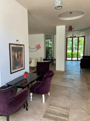 a living room with a table and purple chairs at Seaside View Apartment in Varna in Varna City
