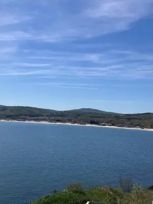 a large body of water with a beach in the distance at Апартамент Лариди in Sozopol