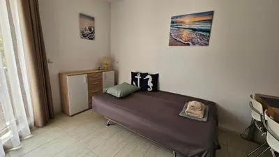 a bedroom with a bed and a dresser at Sea and Sand Apartment in Sozopol