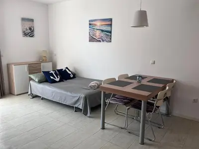 a small room with a bed and a table at Sea and Sand Apartment in Sozopol
