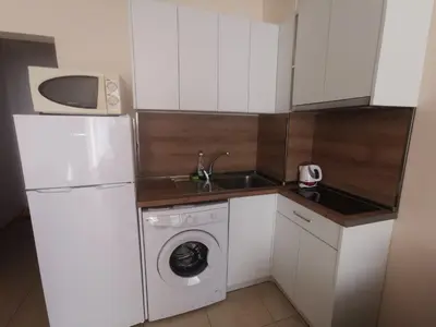 a kitchen with a white refrigerator and a washing machine at Студиa Блу минута от плажа in Pomorie