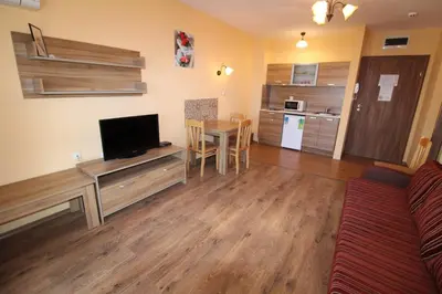 a living room with a couch and a table with a television at Horizont - Menada Apartments in Sunny Beach