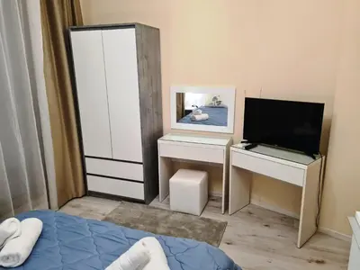 a bedroom with a bed and a tv and a desk at Sunrise Luxury Sauth Bay in Varna City