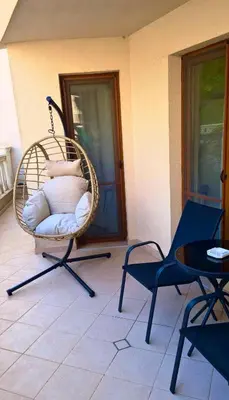 a wicker chair sitting on a patio with a table at Sunrise Luxury Sauth Bay in Varna City