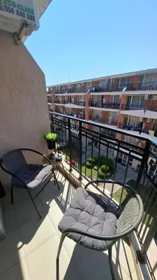 a balcony with two chairs and a table and a building at Апартаменты с одной спальней Carolina in Sunny Beach