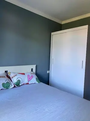 a bedroom with a white bed and a blue wall at Santa Marina, Lovely 1-bedroom apartment in Sozopol