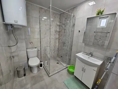 a bathroom with a shower and a toilet and a sink at Къща за гости Ани in Chernomorets