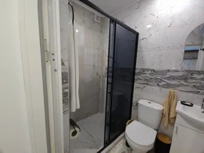 a bathroom with a toilet and a glass shower at Къща за гости Ани in Chernomorets