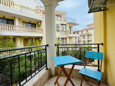 a blue table and chairs on a balcony with buildings at HORIZON 18 'Б' Apartment Sveti Vlas in Sveti Vlas