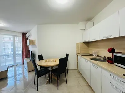 a kitchen with a table and chairs and a sink at HORIZON 18 'Б' Apartment Sveti Vlas in Sveti Vlas