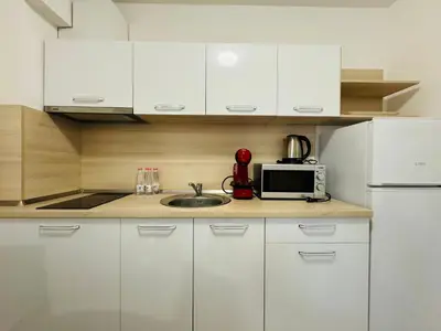 a kitchen with white cabinets and a sink and a microwave at HORIZON 17 'Б' Apartment Sveti Vlas in Sveti Vlas