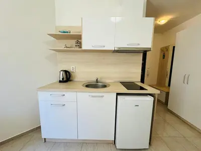 a small kitchen with white cabinets and a sink at HORIZON 11 'Б' Studio Sveti Vlas in Sveti Vlas