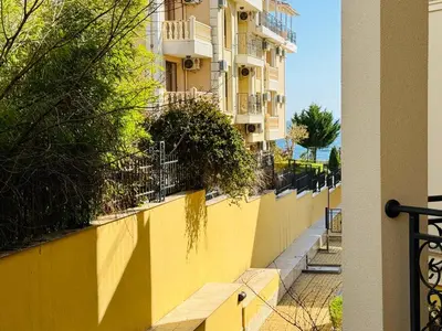 a yellow wall next to a building at HORIZON 9 'Б' Apartment Sveti Vlas in Sveti Vlas