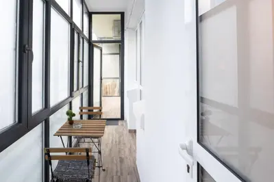 a hallway with a table and chairs and windows at Seaside Estate - Cozy and Romantic - Public Parking Nearby in Varna City