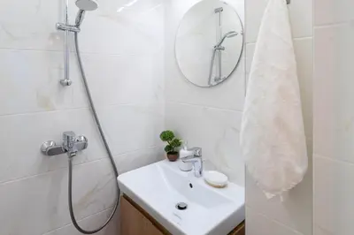 a white bathroom with a sink and a shower at Seaside Estate - Cozy and Romantic - Public Parking Nearby in Varna City