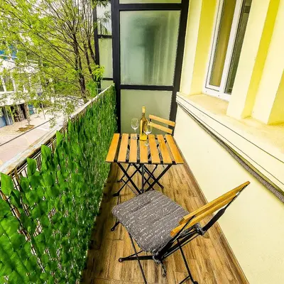 a chair and a table on a balcony at Seaside Estate - Cozy and Romantic - Public Parking Nearby in Varna City