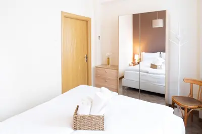 a white bedroom with a bed and a mirror at Seaside Estate - Cozy and Romantic - Public Parking Nearby in Varna City