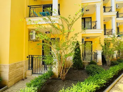 a yellow building with a tree in front of it at HORIZON 3 'Б' Studio Sveti Vlas in Sveti Vlas