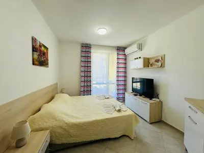 a small bedroom with a bed and a television at HORIZON 3 'Б' Studio Sveti Vlas in Sveti Vlas