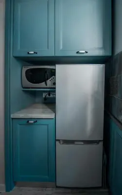 a kitchen with blue cabinets and a refrigerator at Apartment Bellissima 2 minutes away from the beach in Nesebar