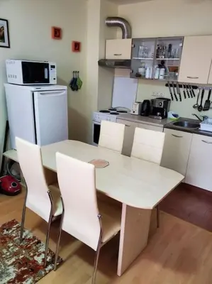 a kitchen with a white table and white chairs at Привилидж первая линия in Sveti Vlas