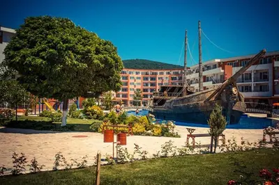 a large boat sitting in a marina next to a building at Привилидж первая линия in Sveti Vlas