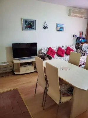 a living room with a table and a couch at Привилидж первая линия in Sveti Vlas