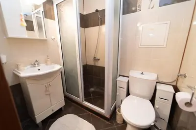a bathroom with a shower and a toilet and a sink at Апартамент за гости Уют in Burgas City