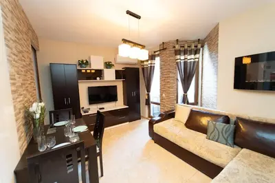 a living room with a couch and a table at Апартамент за гости Уют in Burgas City