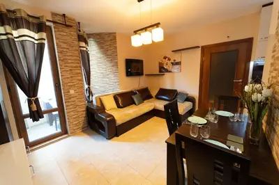 a living room with a couch and a table at Апартамент за гости Уют in Burgas City