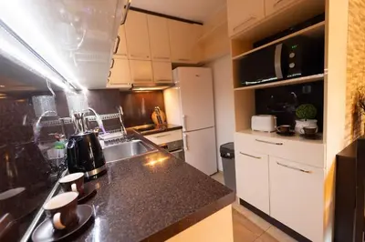 a kitchen with a sink and a counter top at Апартамент за гости Уют in Burgas City