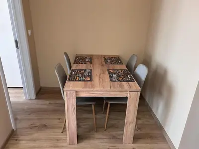 a wooden table with chairs around it in a room at Апартаменти Bella Deluxe in Ravda