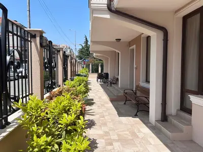 a walkway of a building with benches and plants at Апартаменти Bella Deluxe in Ravda