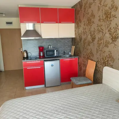 a small kitchen with red cabinets and a microwave at Delta River Park in Sunny Beach