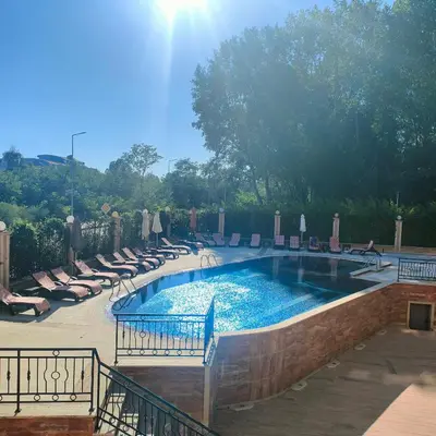 a large swimming pool with lounge chairs in a resort at Delta River Park in Sunny Beach