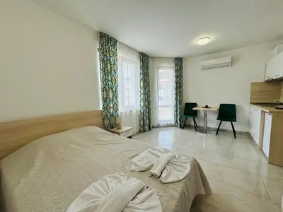 a bedroom with a bed and a table with chairs at HORIZON 27 'В' Studio Sveti Vlas in Sveti Vlas
