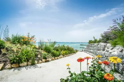a walkway with flowers and the ocean in the background at Premier Fort Apartment on Seafront in Sveti Vlas