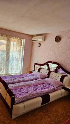 a bedroom with a large bed with purple sheets at Хоризонт in Nesebar