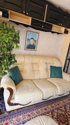 a white couch in a room with a picture on the wall at Хоризонт in Nesebar