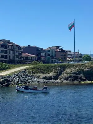 a boat in a body of water with a flag at Порт Лозенец Морска Гледка - Port Lozenets Sea View in Lozenets
