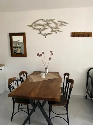 a dining room table with chairs and a vase with flowers on it at Порт Лозенец Морска Гледка - Port Lozenets Sea View in Lozenets