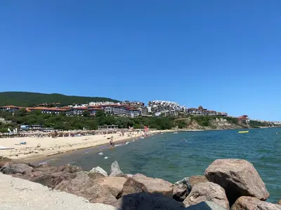 a beach with a group of people in the water at HORIZON 10 'В' Apartment Sveti Vlas in Sveti Vlas