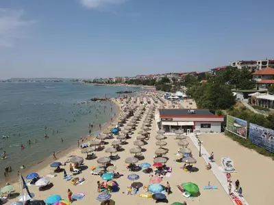 a beach with many umbrellas and people in the water at HORIZON 10 'В' Apartment Sveti Vlas in Sveti Vlas