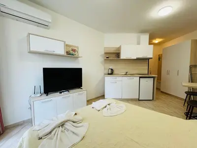 a room with a bed and a flat screen tv at HORIZON 3 'В' Studio Sveti Vlas in Sveti Vlas