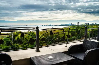 a balcony with chairs and a view of the water at Milano Hotel in Burgas City
