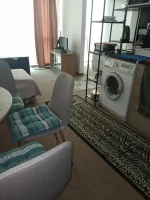 a living room with a washing machine and a chair at Клара in Burgas City