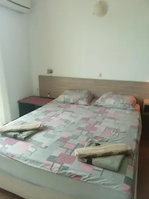 a bedroom with a bed with a pink and white quilt at Клара in Burgas City