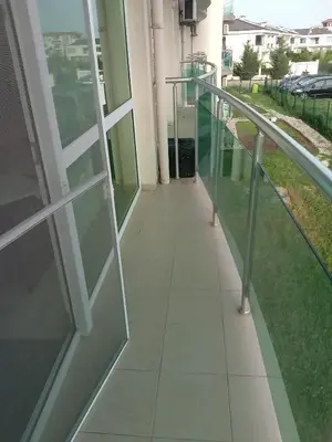 a walkway outside of a building with glass railing at Клара in Burgas City